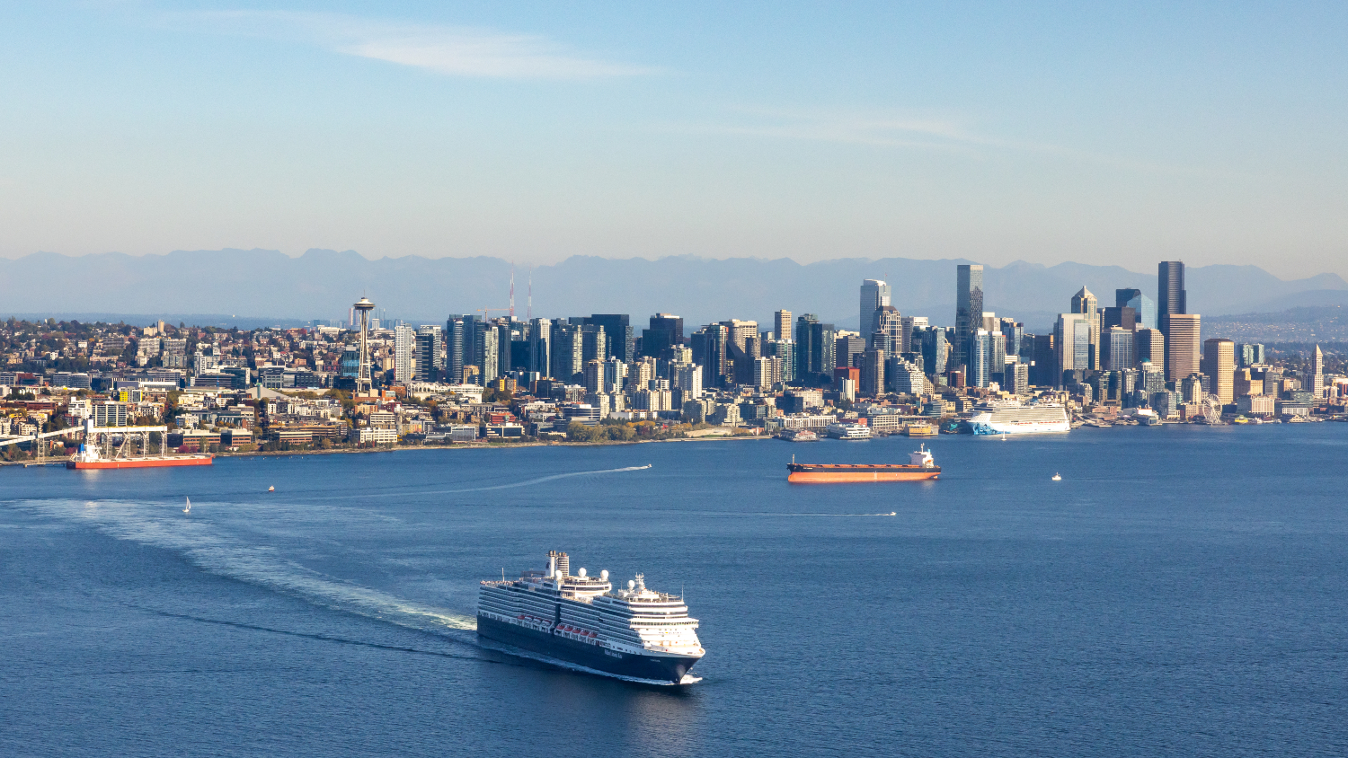 Aerial photo of the Seattle waterfront with a cruise ship leaving the city and another at port