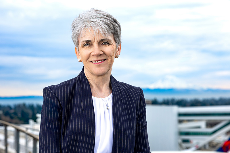 Wendy Reiter smiling on a rooftop, with the Seattle skyline in the background.
