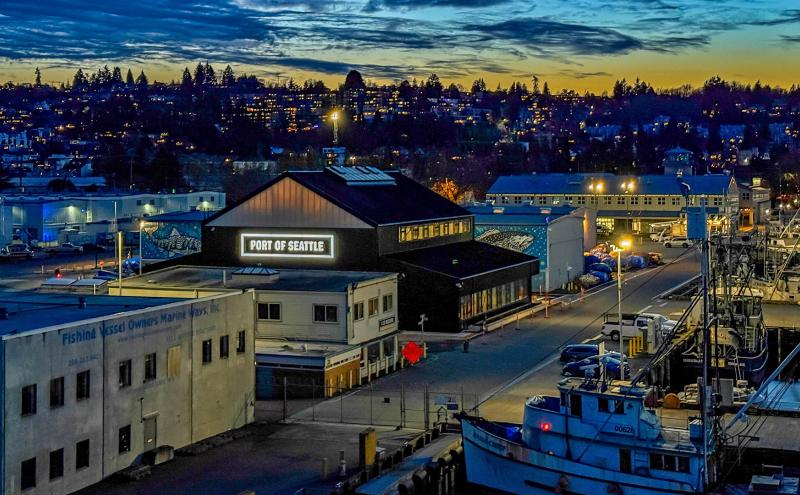 Fishermen's Terminal building shots at night time with Port of Seattle sign lit up on Maritime Innovation Center building.