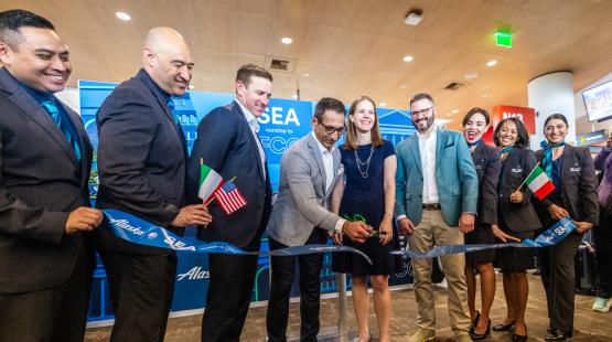 Representatives from Alaska Airlines and the Port of Seattle pose for a photo and ribbon cutting at the inaugural gate event, celebrating the new nonstop flight from Seattle to Rome.