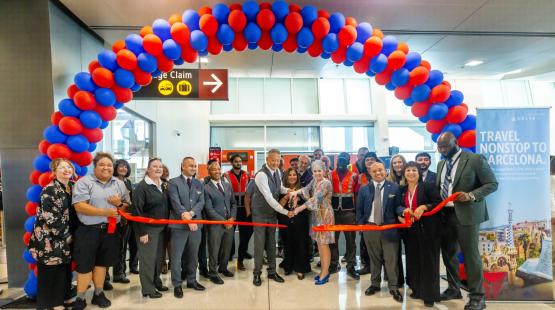 Arch of balloons with people cutting the ribbon to launch two new Delta flights at SEA Airport 