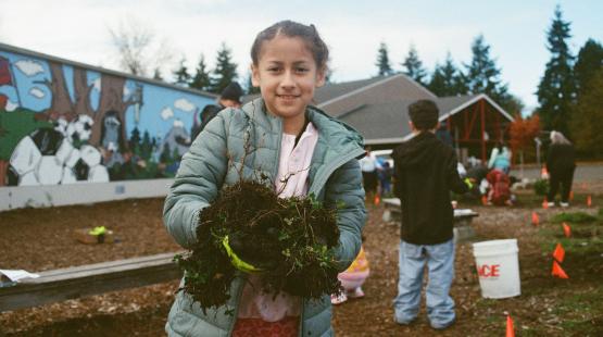 An Seahurst Elementary student works in a rain garden at the school