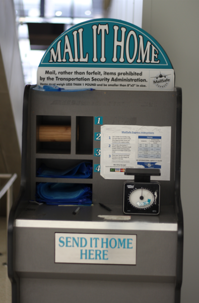 Mail stand with text that reads, "Mail, rather than forfeit, items prohibited by the Transportation Security Administration. Items must weigh less than 1 pound and be smaller than 8'x5' in size."