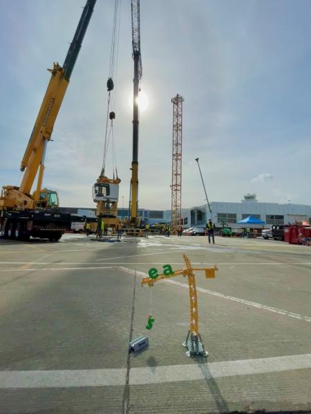 Toy crane in contrast to the real crane