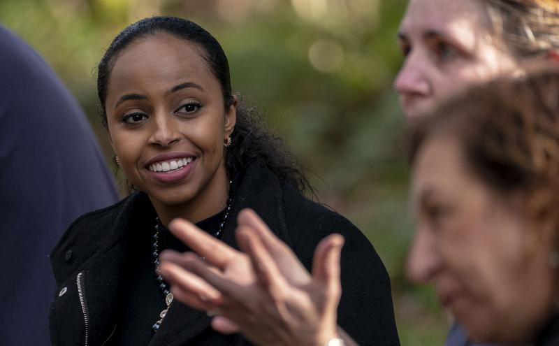 Commissioner Hamdi Mohamed smiling and listening to women at a trees and native speciie shubs planting event