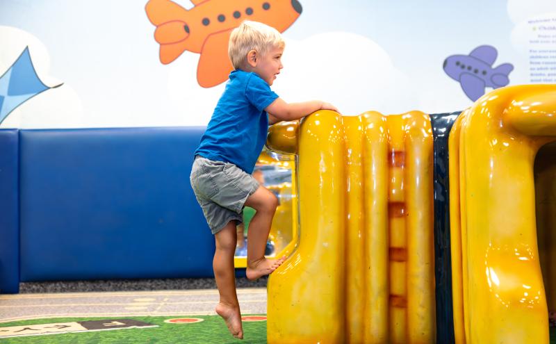 Child climbs play structure.