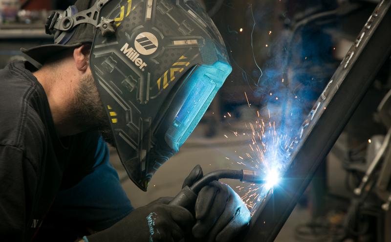 Welder with a mask working on a welding project. 