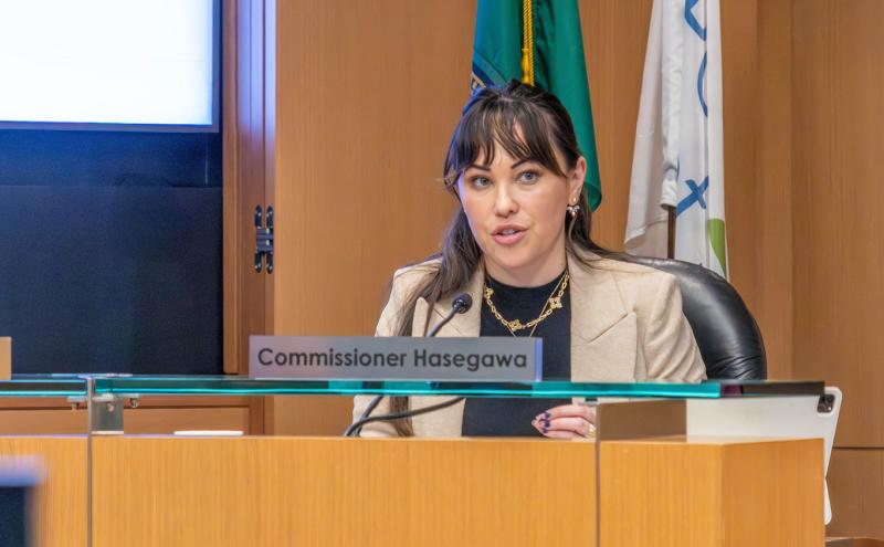 Commissioner Hasegawa behind the podium at a Commission meeting.