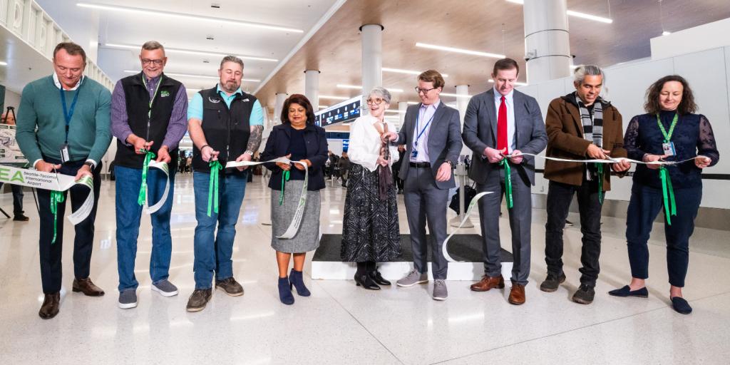 Representatives from the Port of Seattle, Alaska Airlines, and Hensel Phelps cut the ribbon at the SEA Gateway Project's Grand Opening recognition event