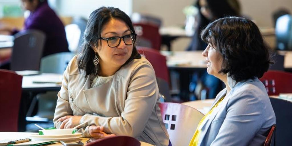 Two women talking in a community meeting