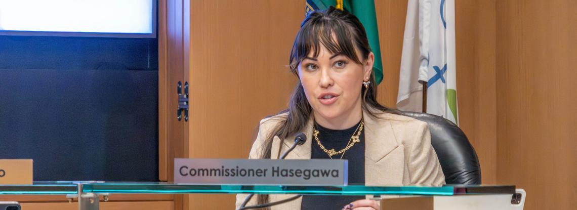 Commissioner Hasegawa at the podium at a Commission meeting.